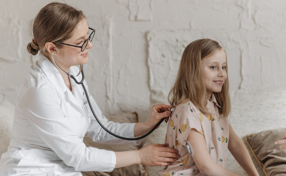 doctor listening to child patient's heart