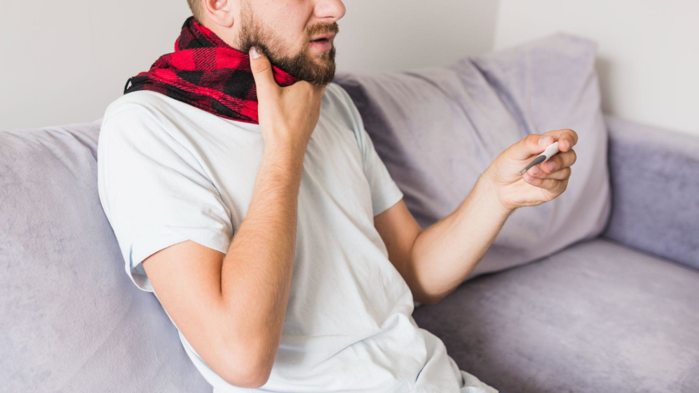 photo of European man with sore throat  and thermometer